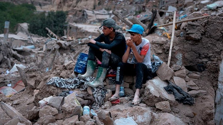 Dos adolescentes sentados sobre ruinas tras el terremoto. Foto: © María Ximena Borrazas/CEAR